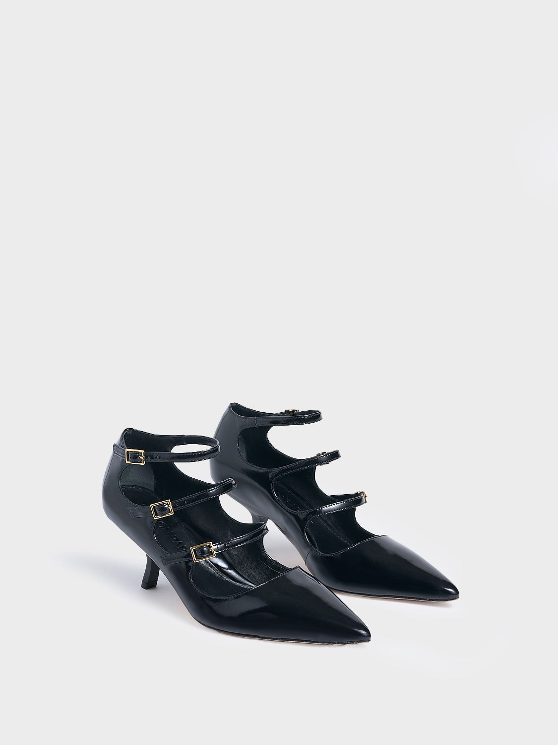 Angle view of a pair of black brushed calf leather mary jane heels with adjustable straps and a pointed toe.