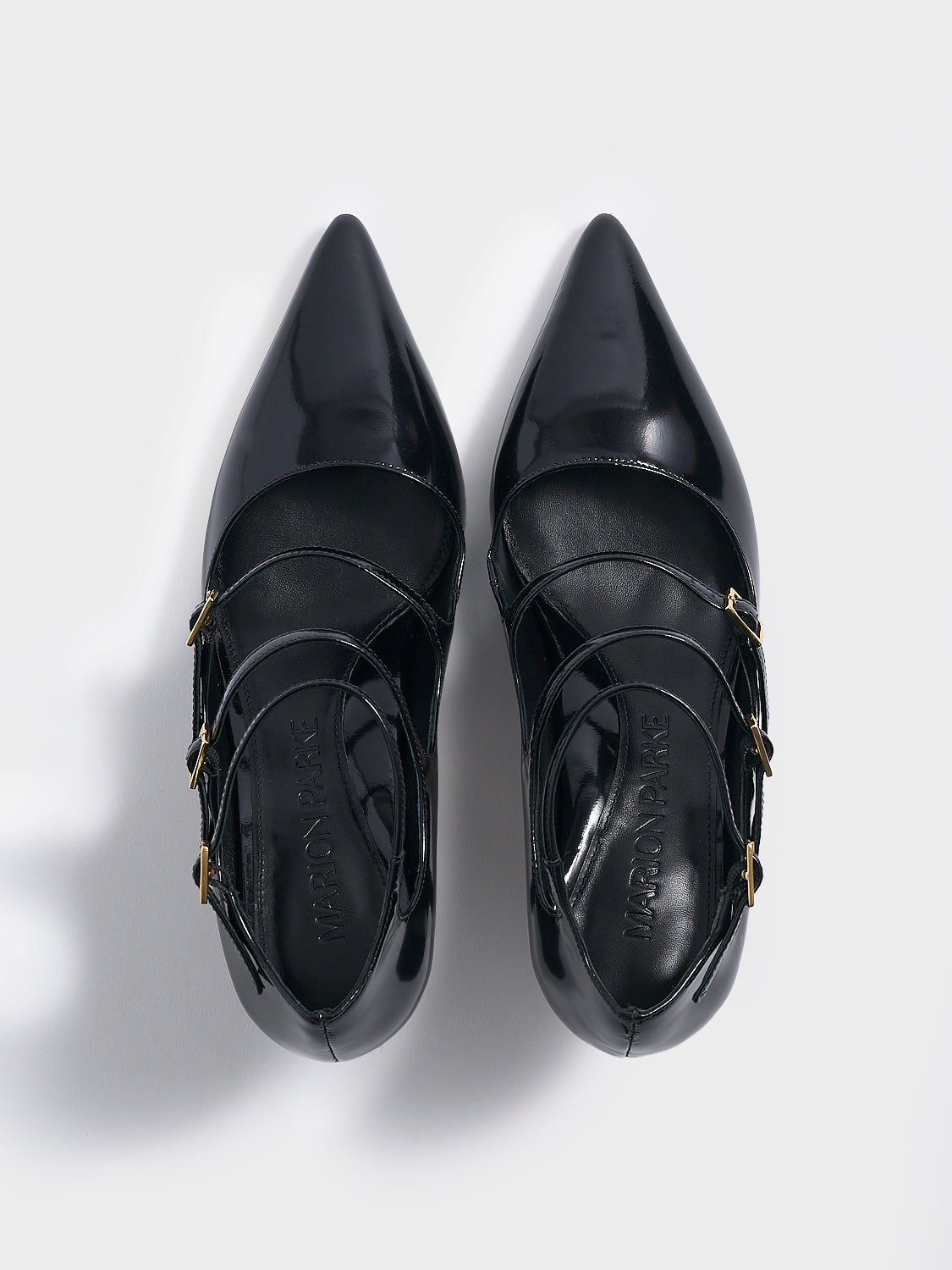 Top view of a pair of black brushed calf leather mary jane heels with adjustable straps and a pointed toe.