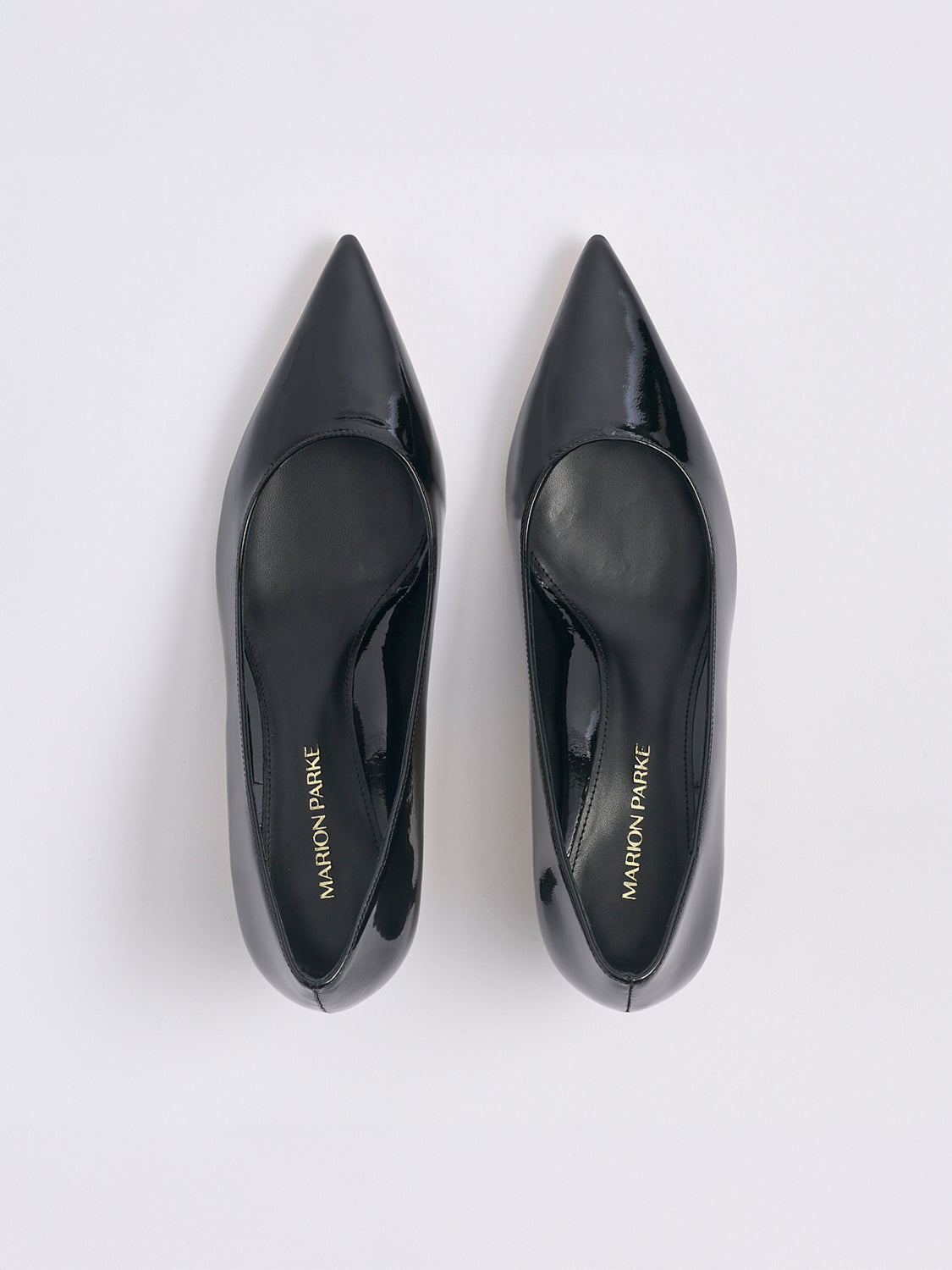 Top view of a pair of black patent leather kitten stiletto heel pumps with a pointed toe.