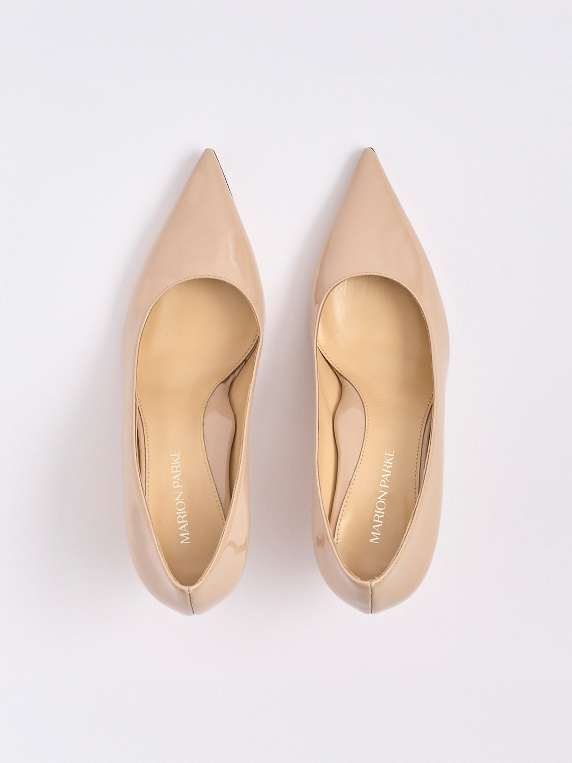 Top view of a pair of powder patent stiletto heel pumps with a pointed toe.