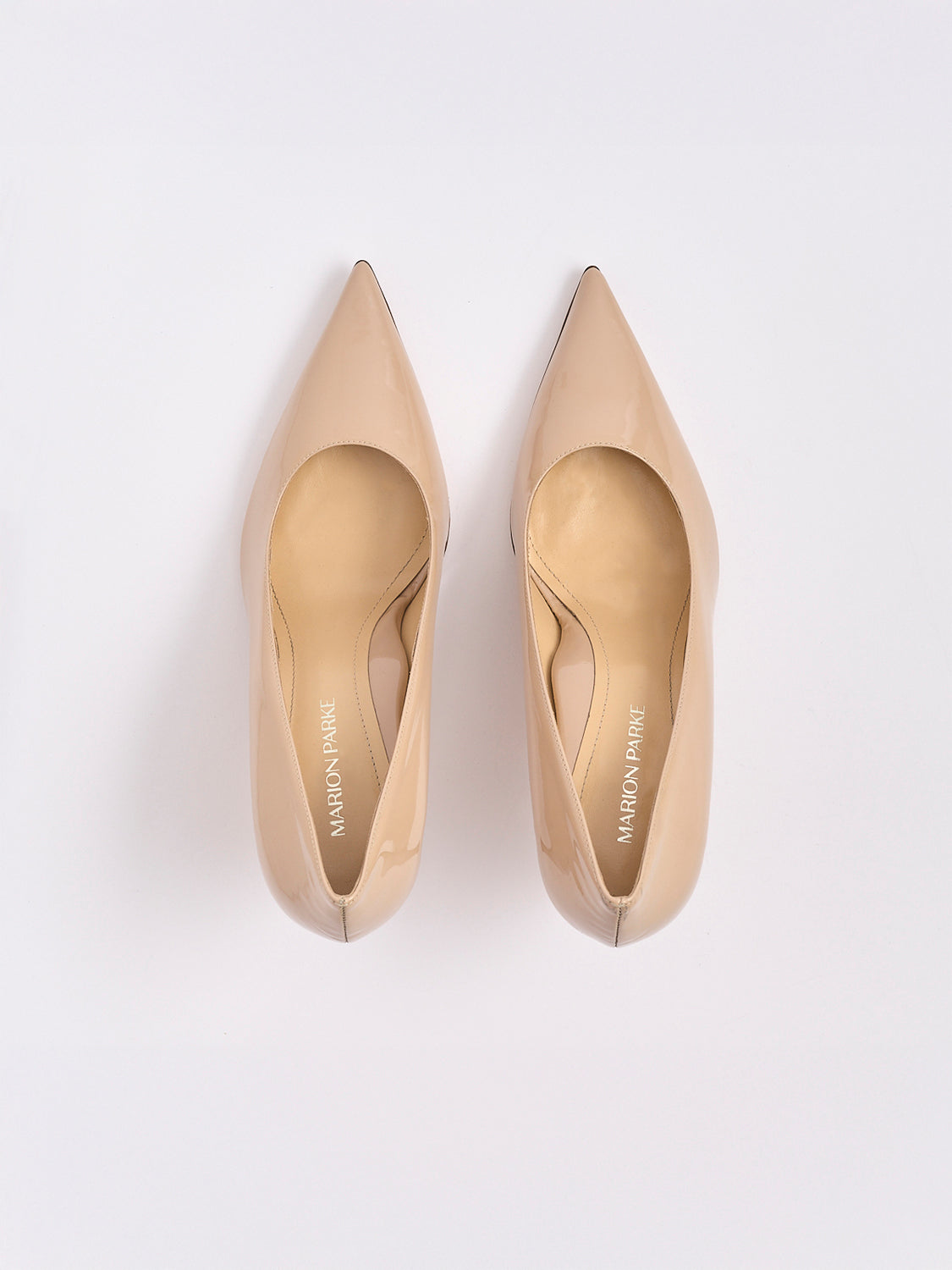 Top view of a pair of powder patent leather high stiletto heel pumps with a pointed toe.