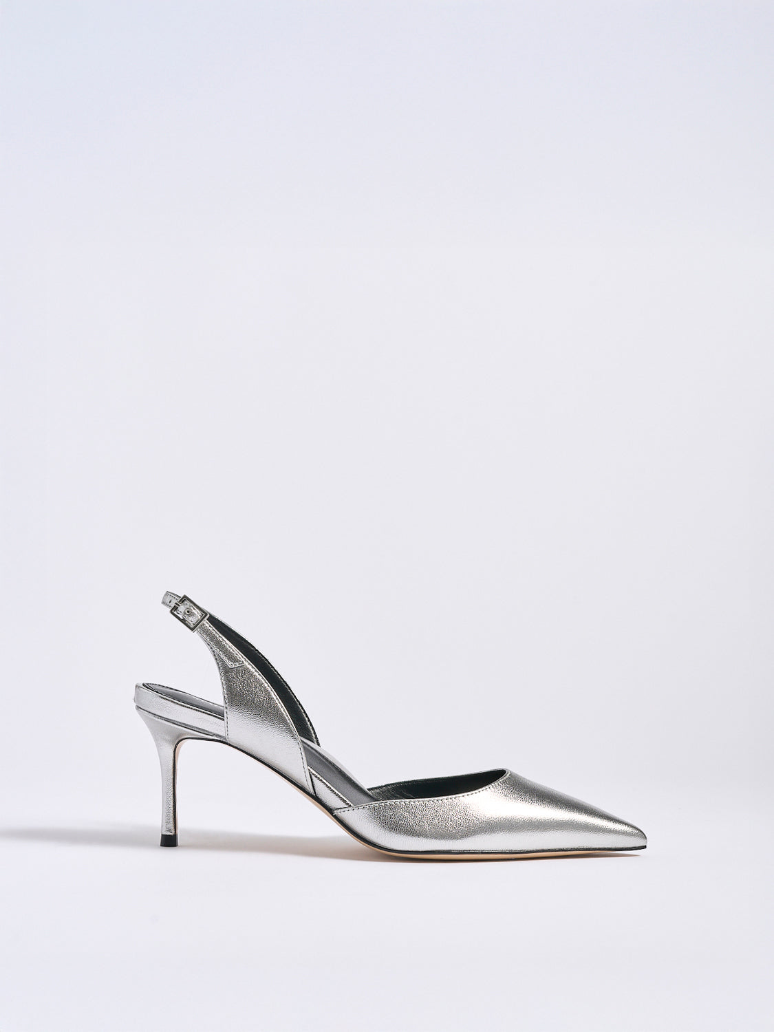 Profile view of a silver metallic leather slingback heel with a pointed toe.