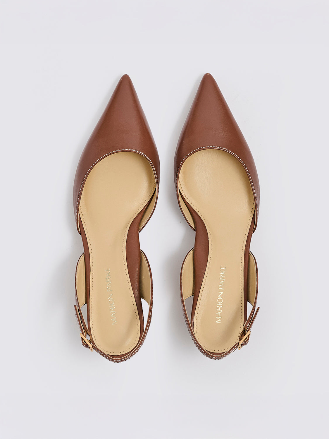 Top view of a pair of luggage leather slingback heels with a pointed toe