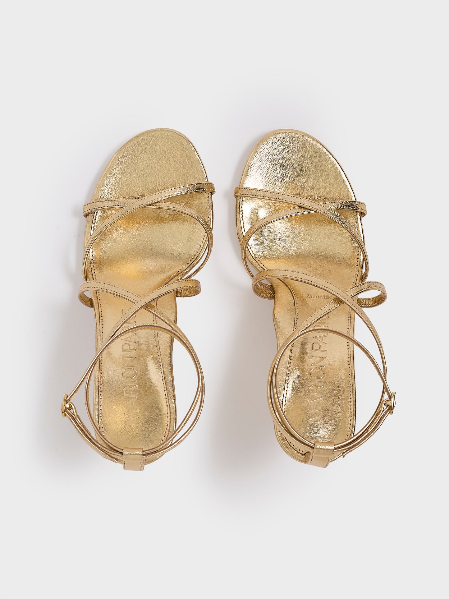 Top view of a pair of black leather high heel strappy sandals with an ankle strap detail.