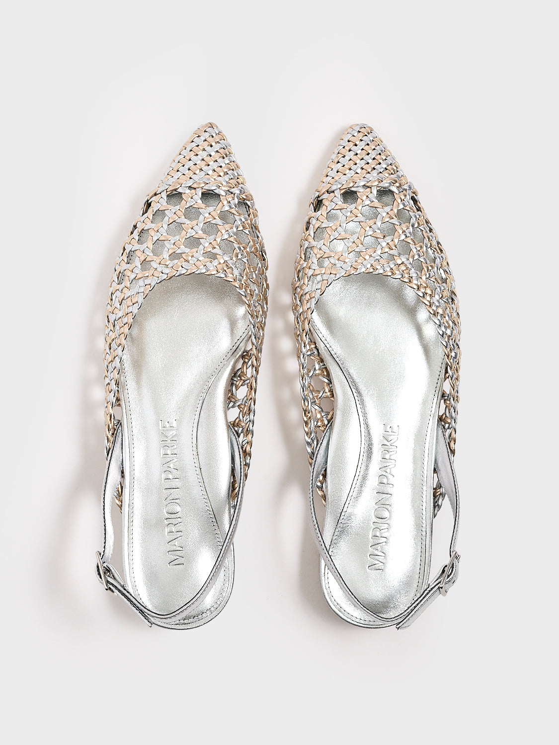 Top view of a pair of silver and gold metallic braided leather slingback flats.
