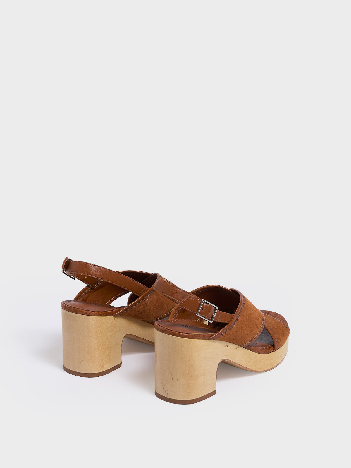 Back view of a pair of chestnut leather block heel sandals with an adjustable ankle strap design.