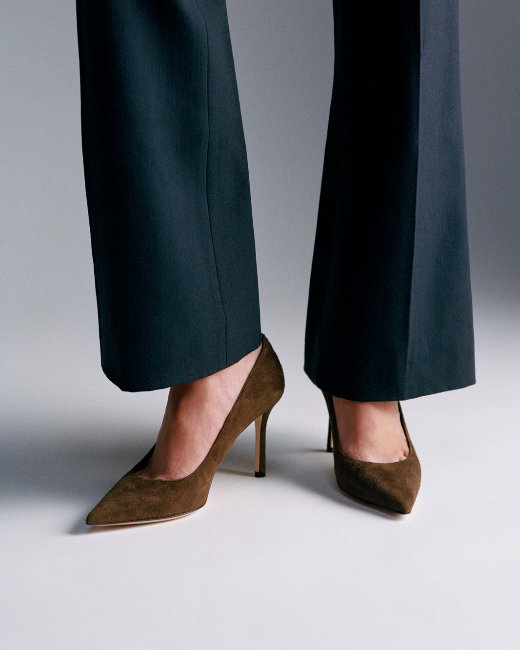 Chocolate suede pumps shown on a model.