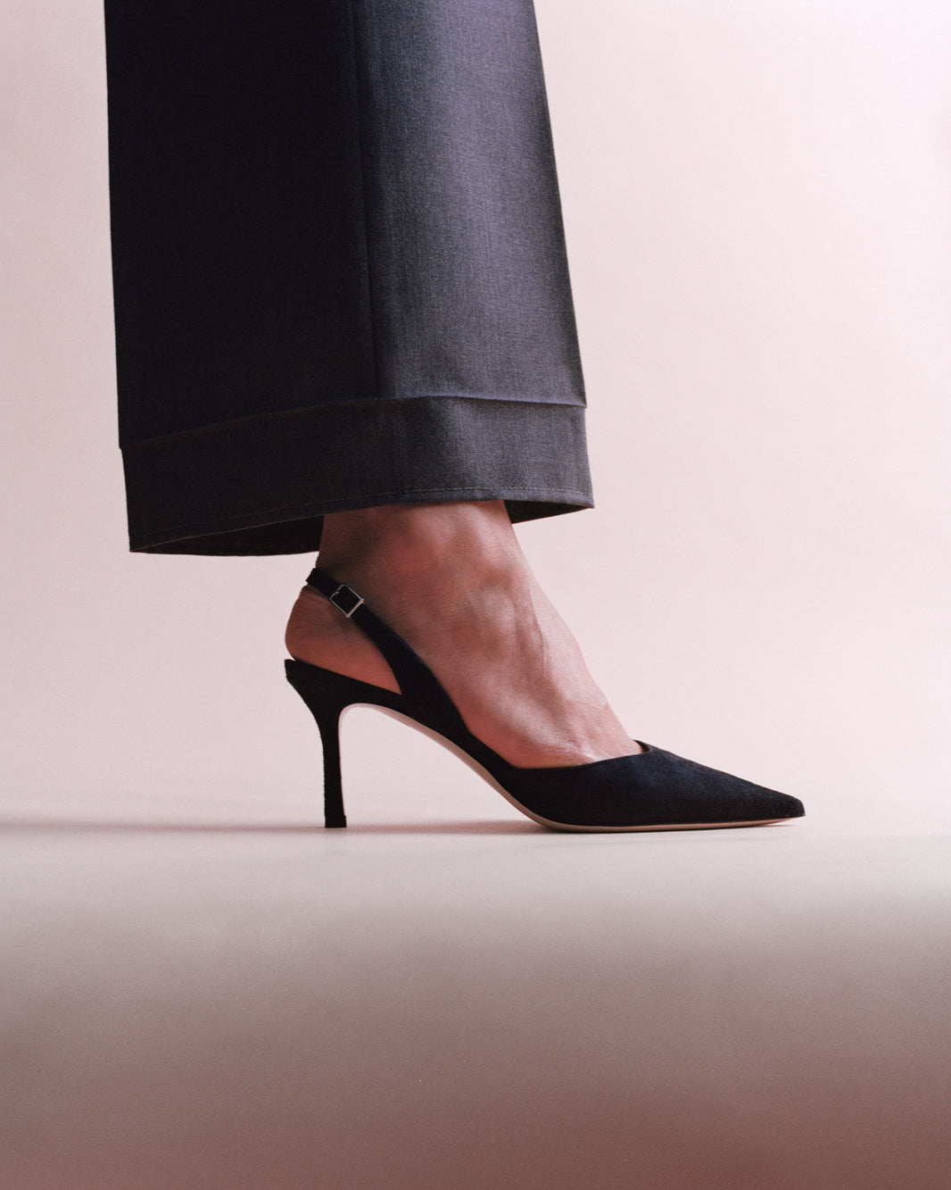 Side view of a navy suede slingback heel, shown on a model.