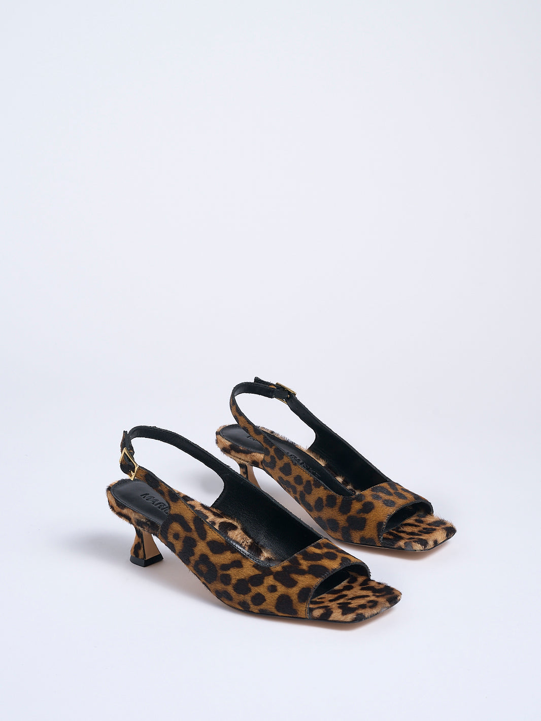 Angle view of a pair of leopard hair calf slingback sandals with a flared kitten heel and square toe detail.