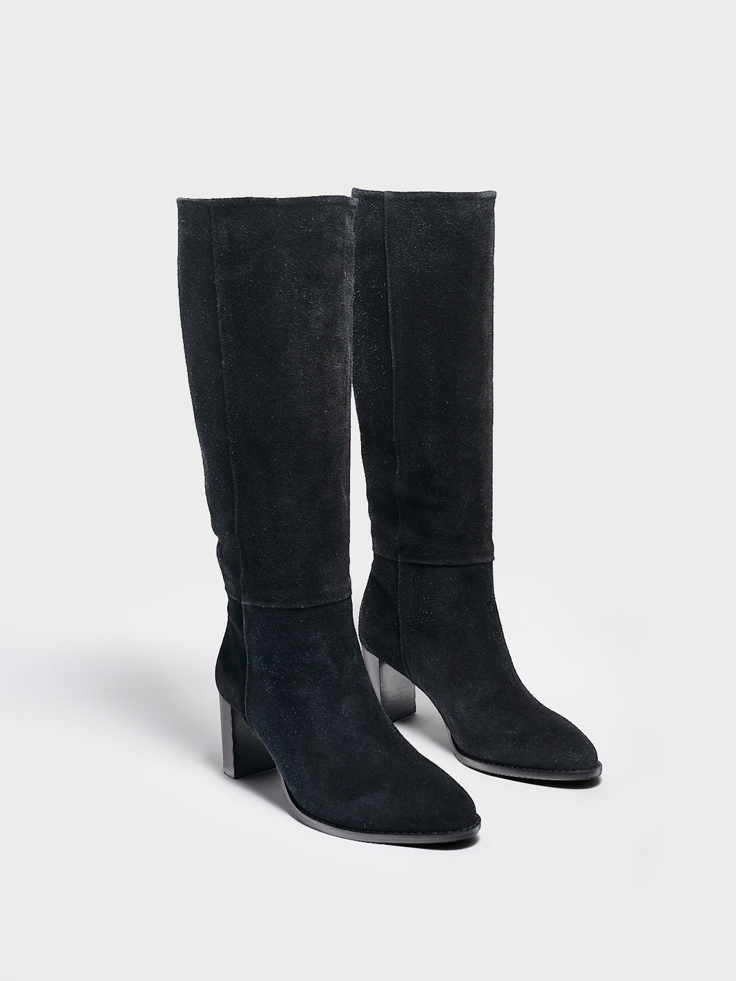 Angle view of a pair of black suede scrunch tall boots with a block heel and round toe.