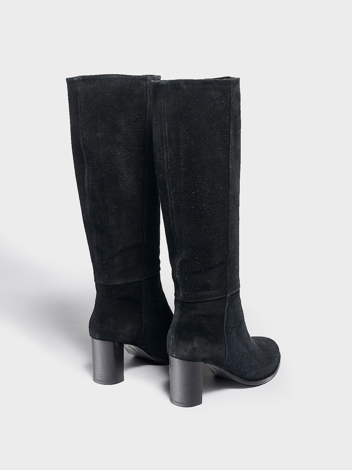 Back view of a pair of black suede scrunch tall boots with a block heel and round toe.