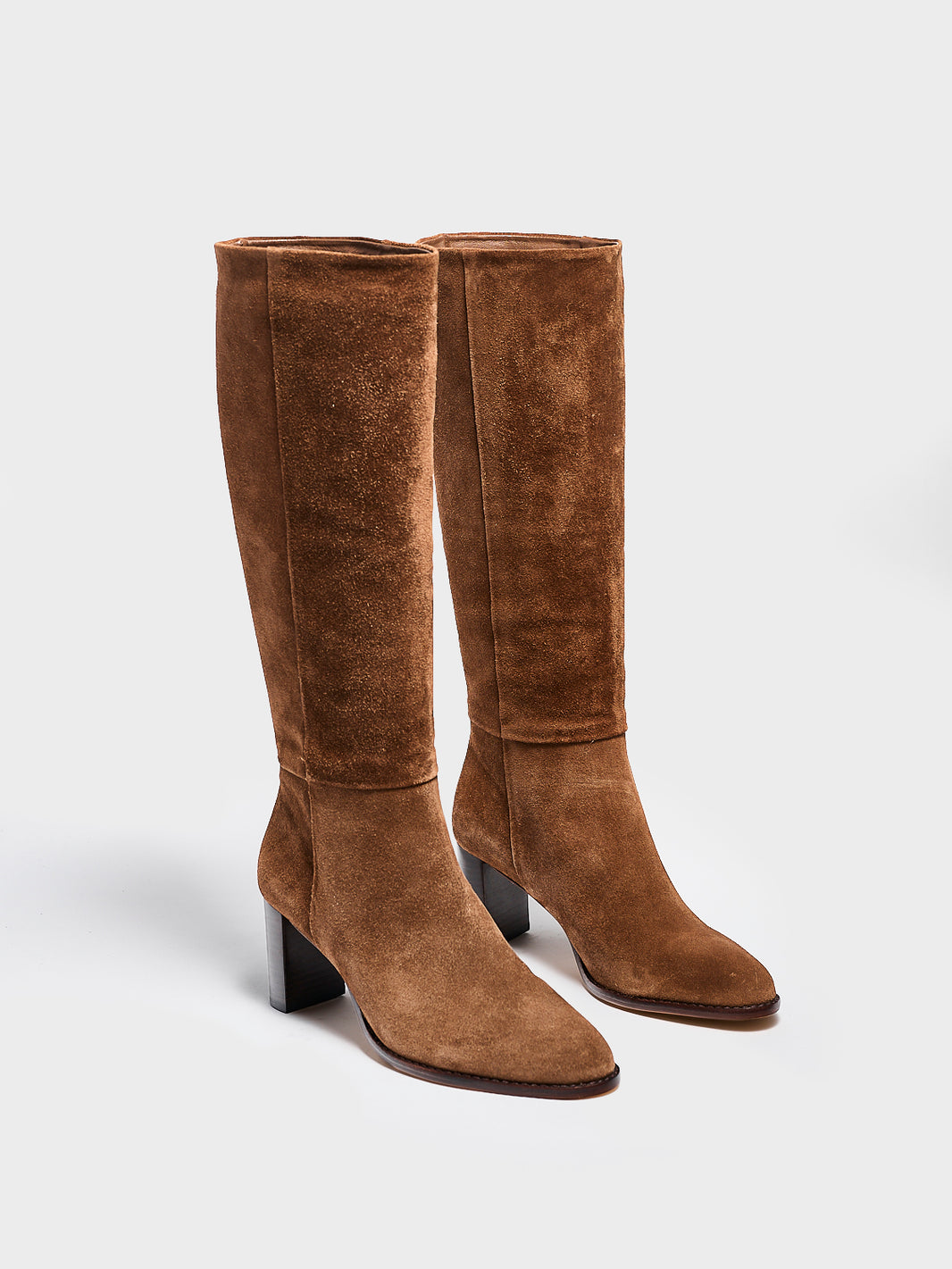 Angle view of a pair of mocha brown suede scrunch tall boot with a block heel and round toe.