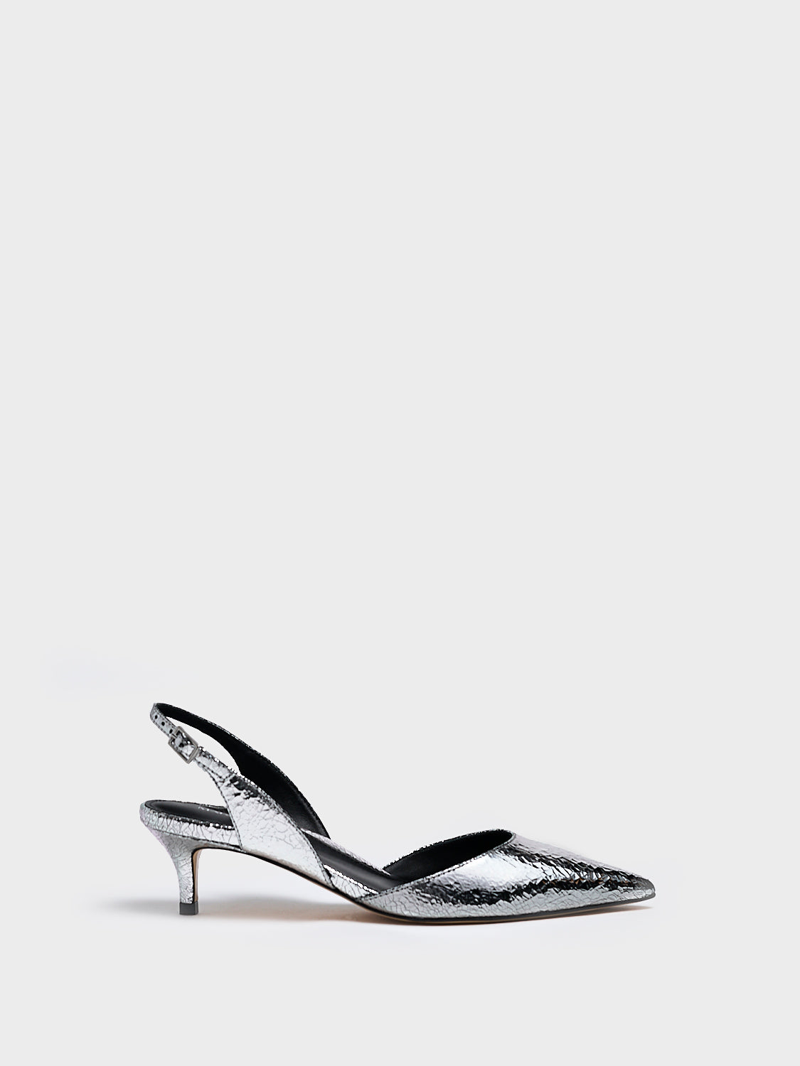Profile view of a silver metallic leather kitten heel slingback with a pointed toe.