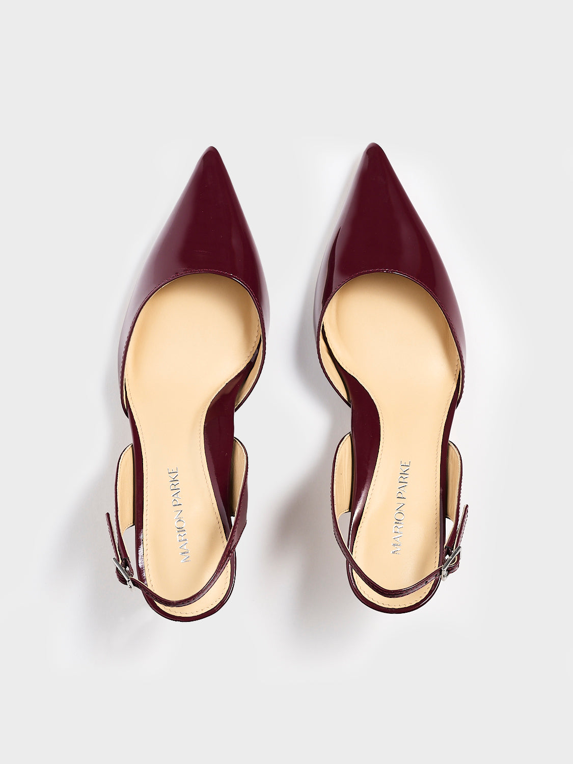 Top view of a pair of merlot red patent leather slingback heel with a pointed toe.