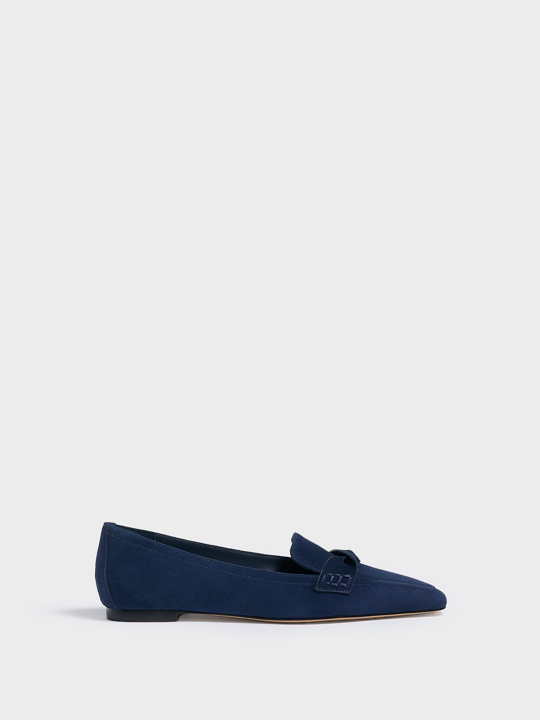 Profile view of a navy blue suede penny loafer with a twist detail.
