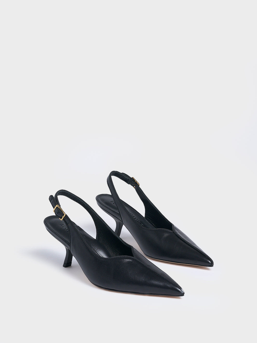 Angle view of a pair of black  leather slingback kitten heels with a grosgrain trim and angled heel detail.