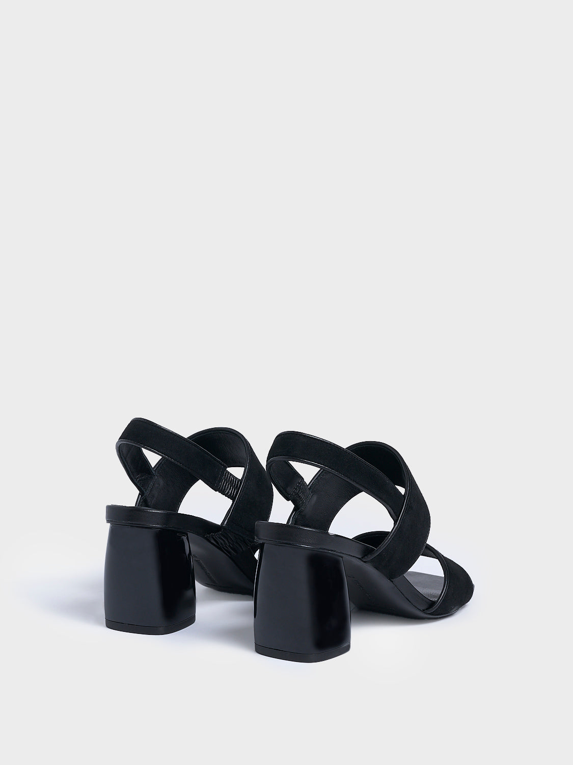 Back view of a pair of black suede block heel sandals with two over the foot straps and a square toe. 