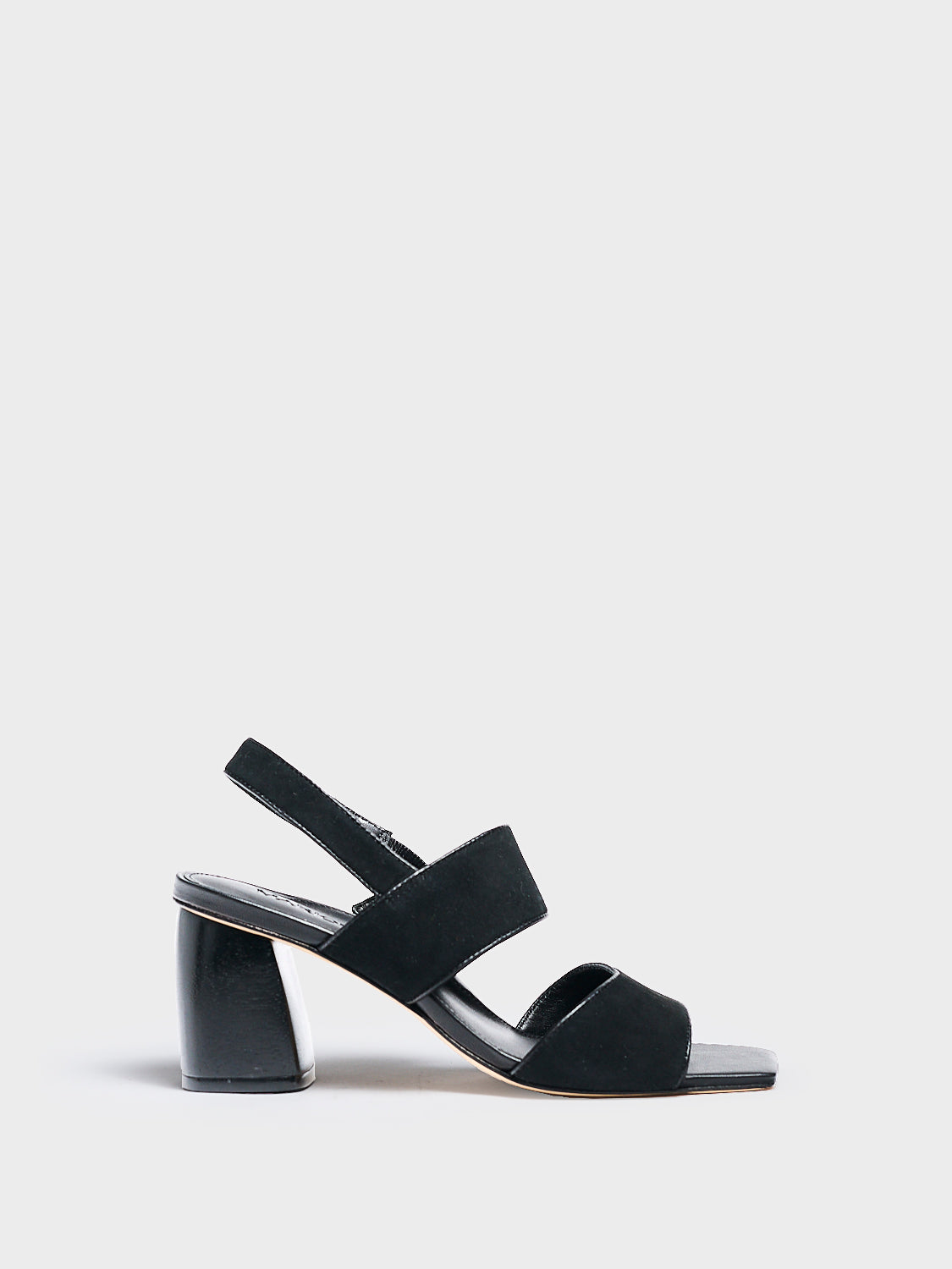 Profile view of a black suede block heel sandal with two over the foot straps and a square toe. 
