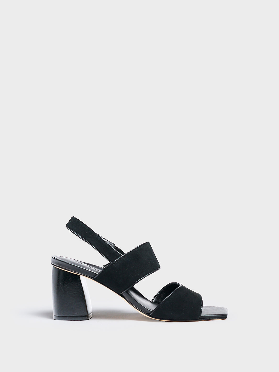 Profile view of a black suede block heel sandal with two over the foot straps and a square toe. 
