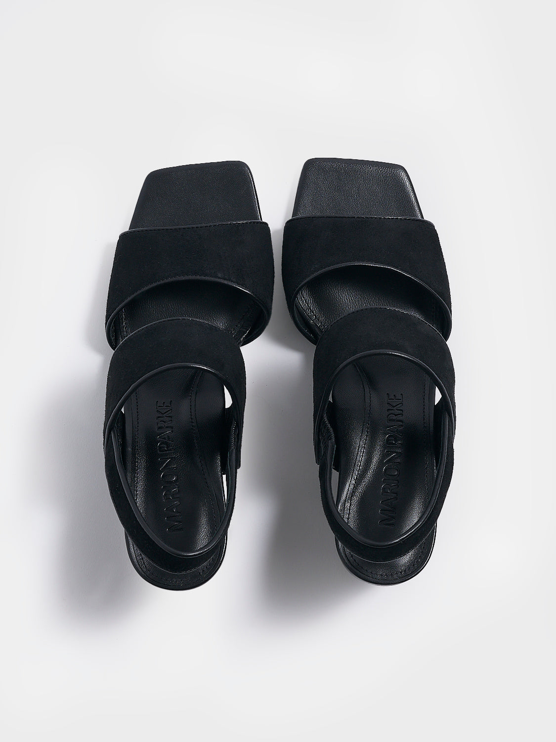 Top view of a pair of black suede block heel sandals with two over the foot straps and a square toe. 