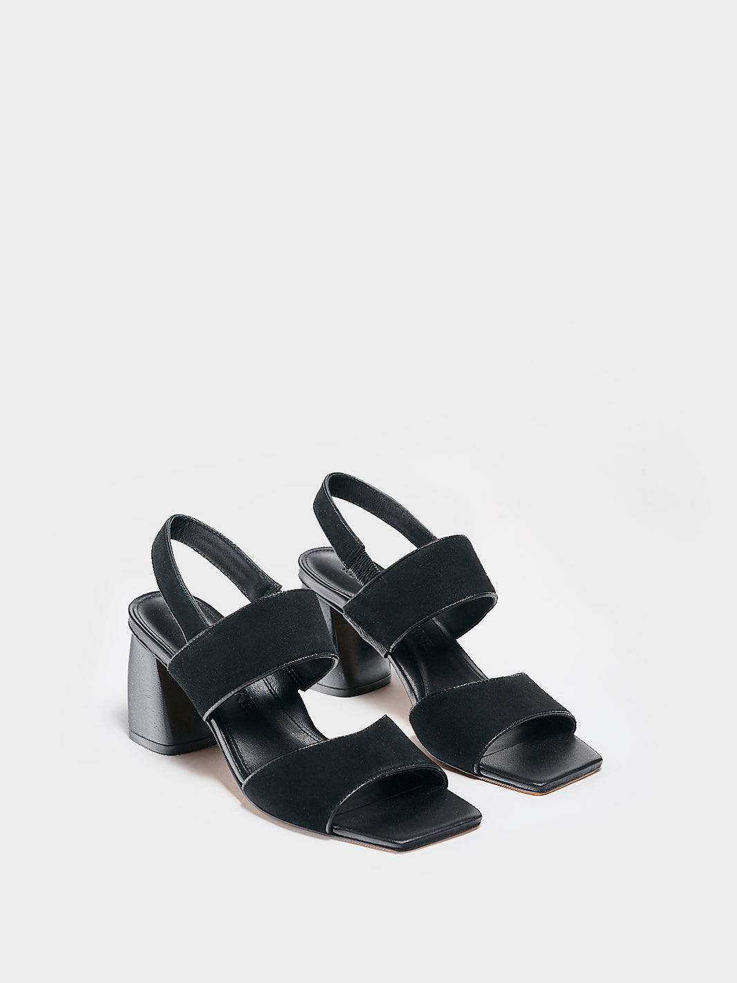 Angle view of a pair of black suede block heel sandals with two over the foot straps and a square toe. 