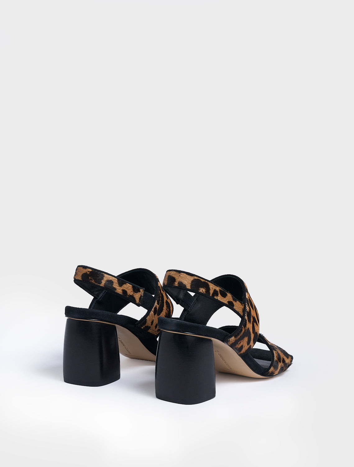 Back view of a pair of leopard print hair calf block heel sandals with two over the foot straps and a square toe. 