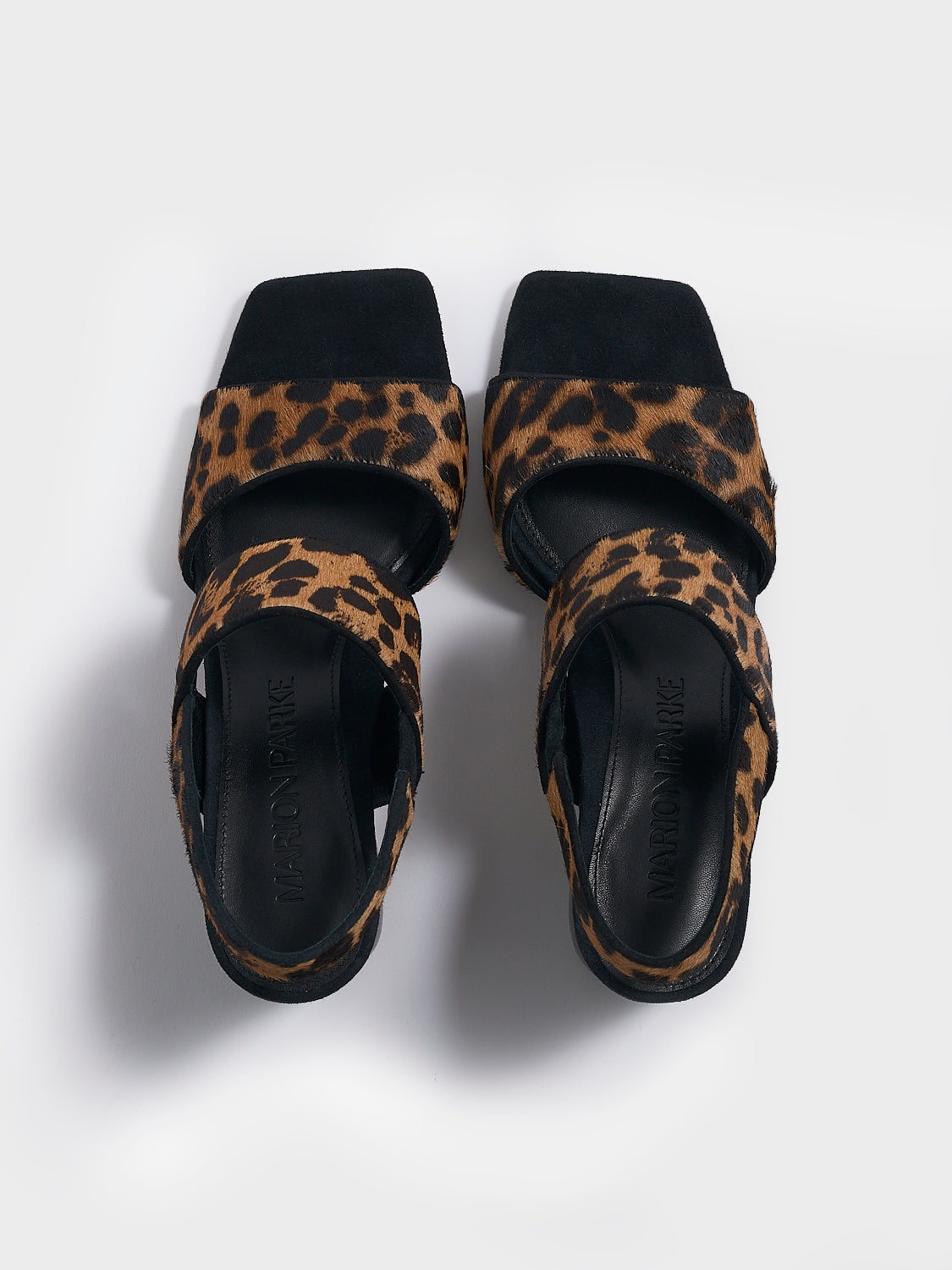 Top view of a pair of leopard print hair calf block heel sandals with two over the foot straps and a square toe. 