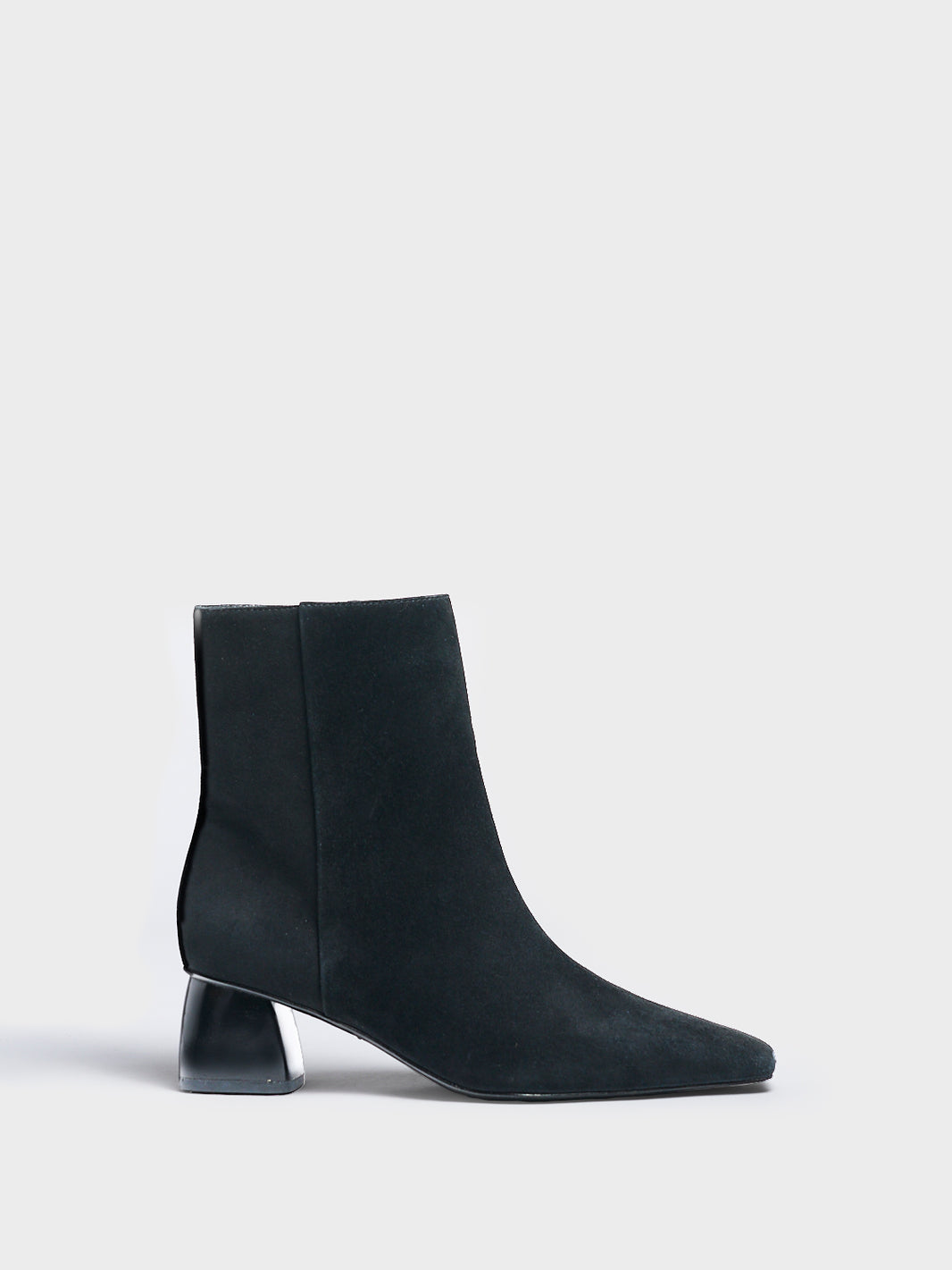 Profile view of a black suede ankle bootie with a rounded heel shape, zipper closure, and square toe. 