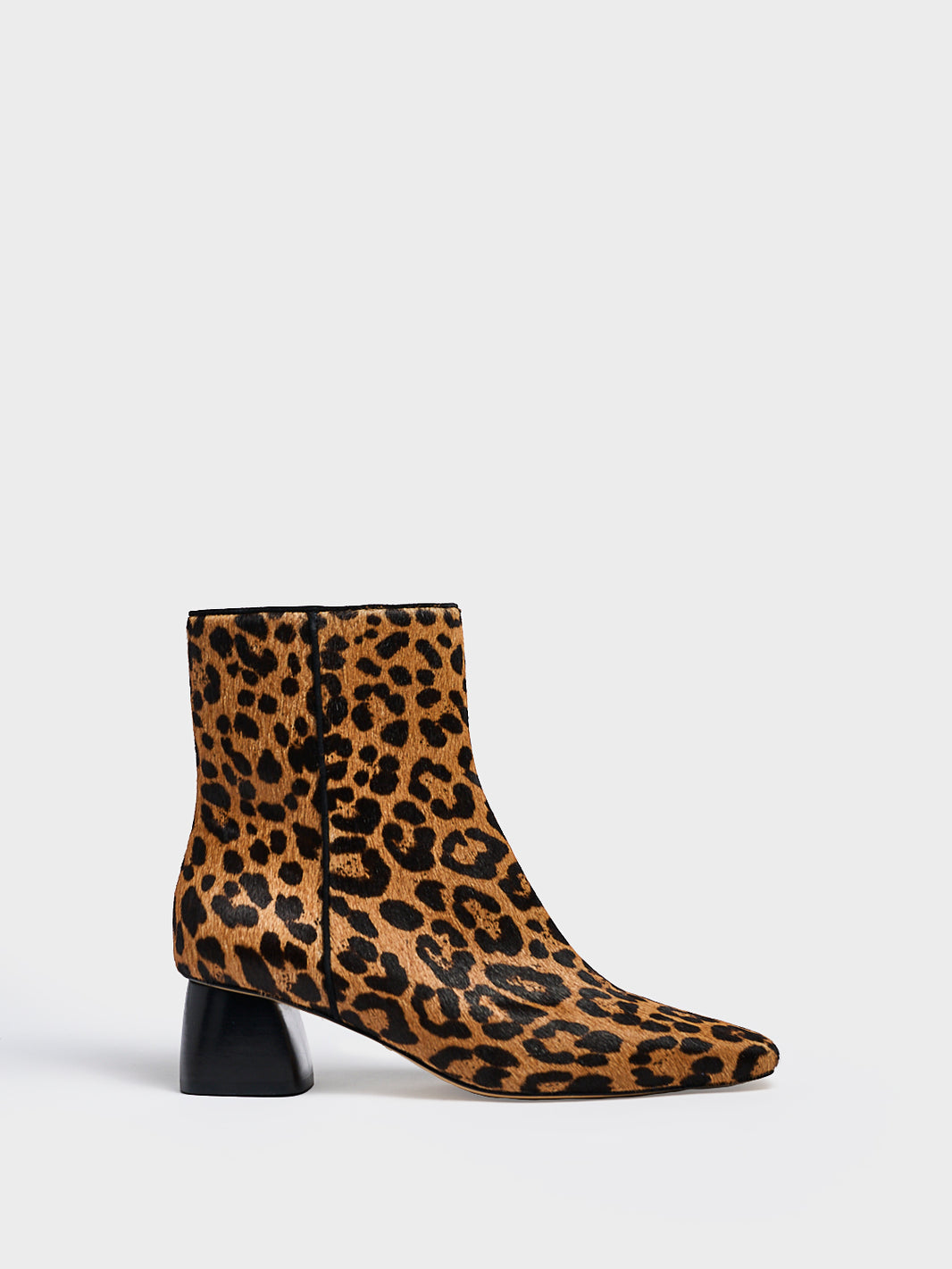 Profile view of a leopard hair calf ankle bootie with a rounded heel shape, zipper closure, and square toe. 