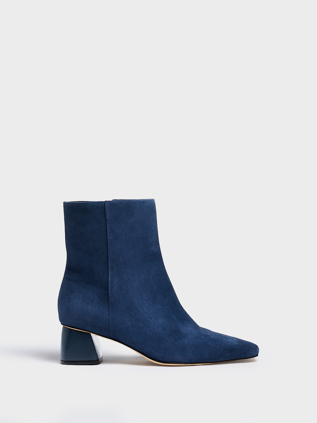Profile view of a navy suede ankle bootie with a rounded heel shape, zipper closure, and square toe. 