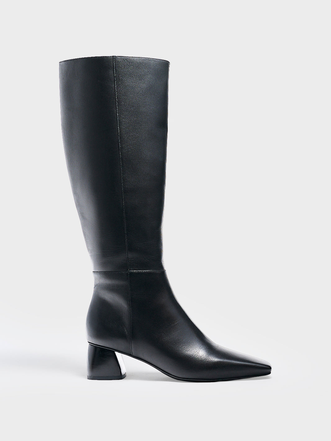 Profile view of a black nappa leather below the knee tall boot with a rounded heel shape, zipper closure, and square toe. 