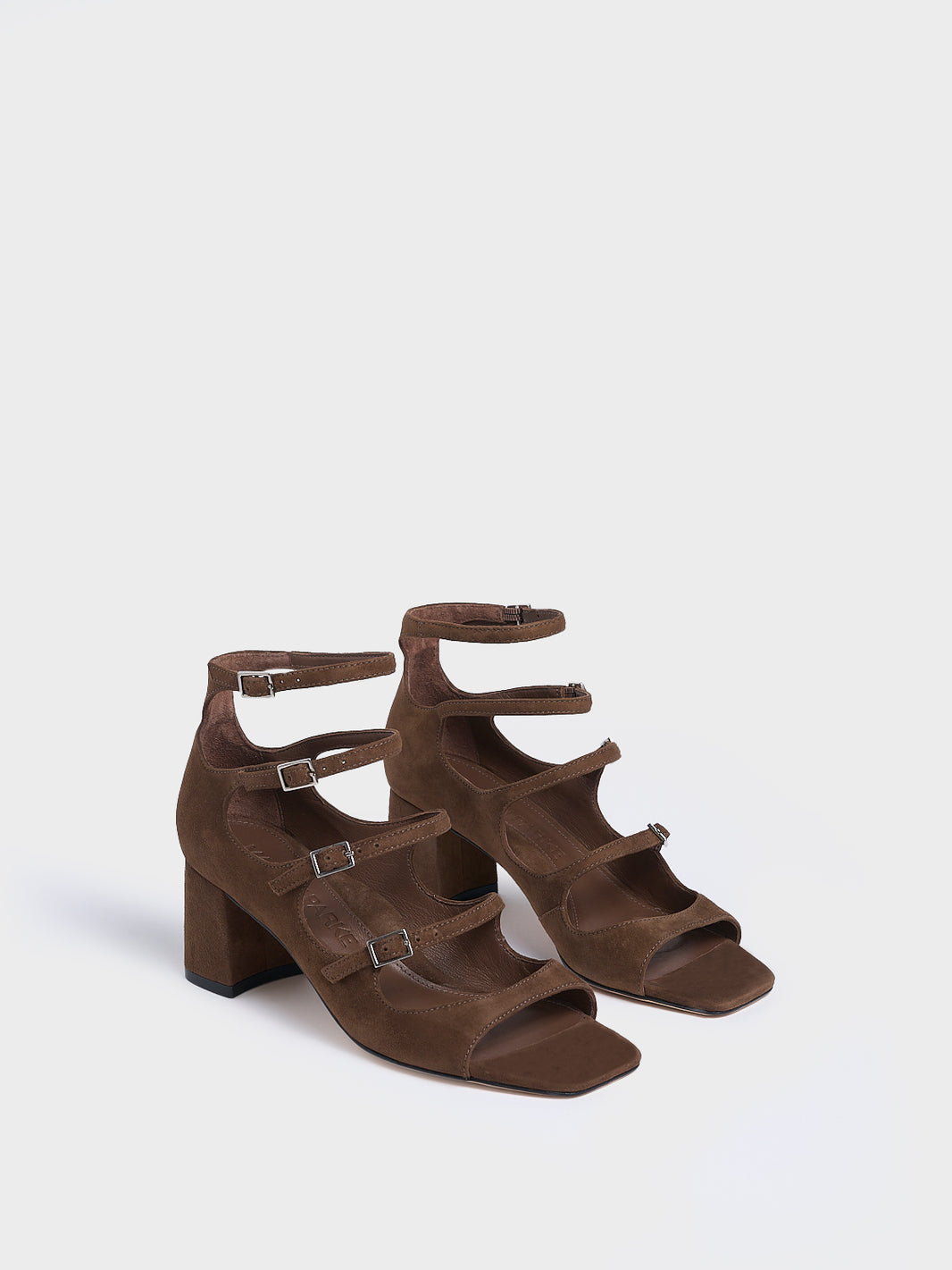 Angle view of a pair of mocha brown suede block heel mary jane sandals with adjustable straps and a square toe. 