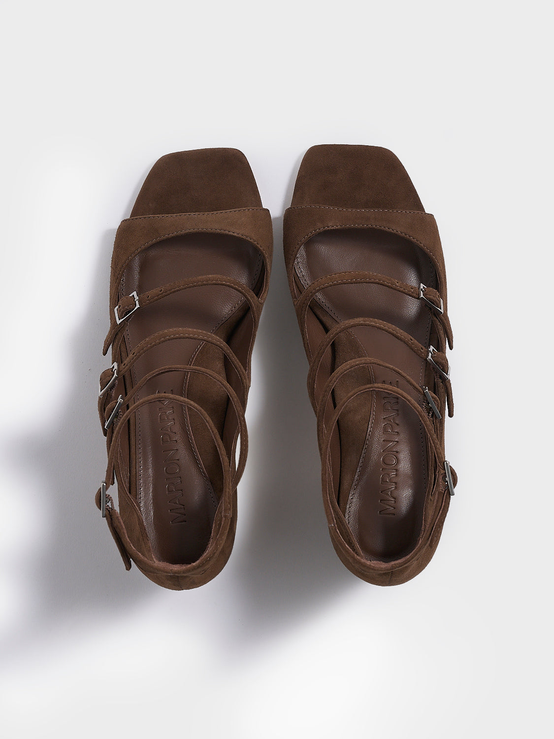 Top view of a pair of mocha brown suede block heel mary jane sandals with adjustable straps and a square toe. 