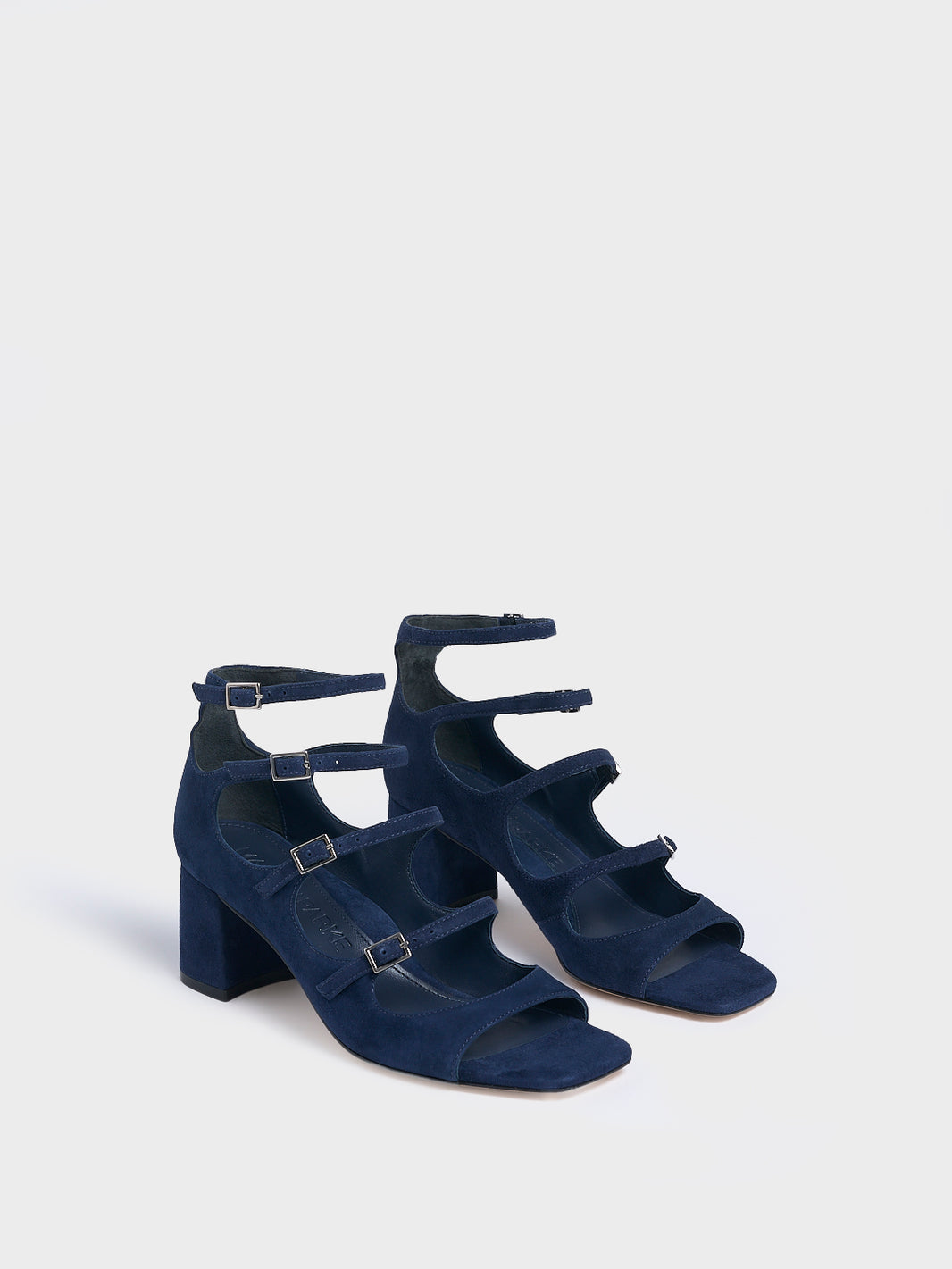 Angle view of a pair of navy blue suede block heel mary jane sandals with adjustable straps and a square toe. 