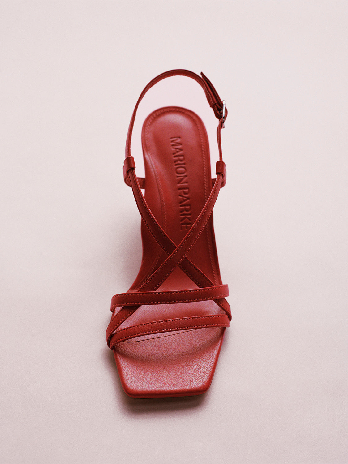 Top view of a lipstick red leather strappy sandal with a sculptural wedge.