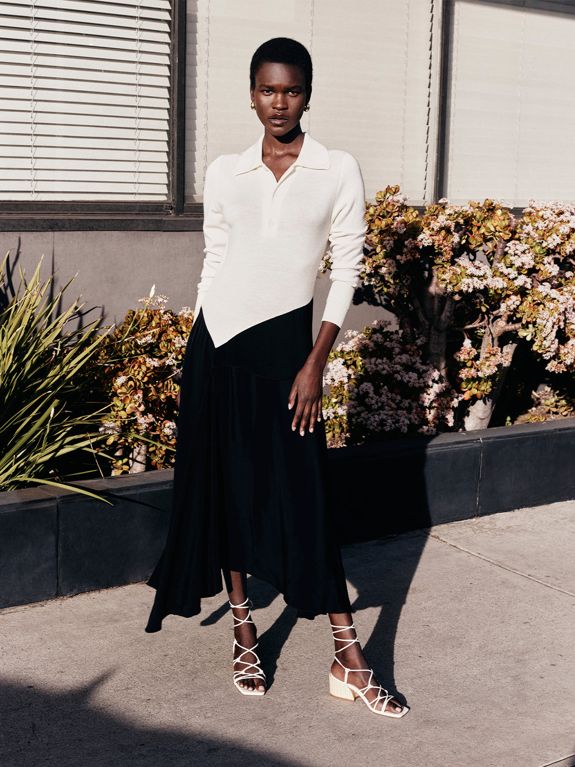 Angled view of ivory leather lace-up sandals with a block heel and square toe, shown on model.