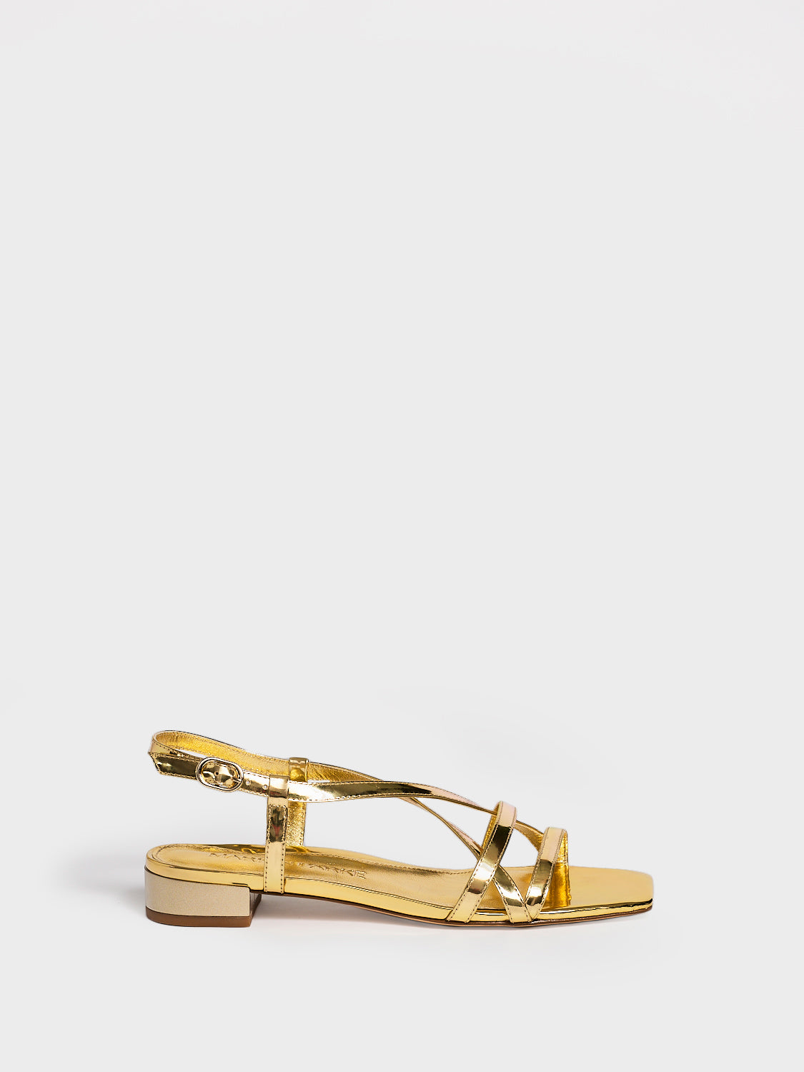 Profile view of a gold metallic leather flat strappy sandal.