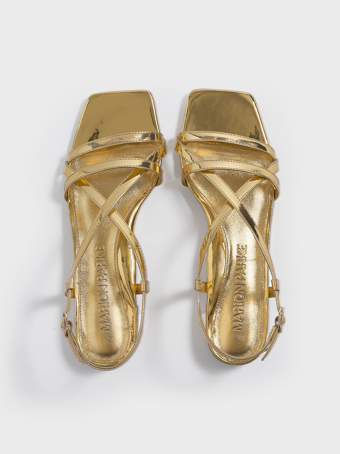 Top view of a pair of gold metallic leather flat strappy sandals.