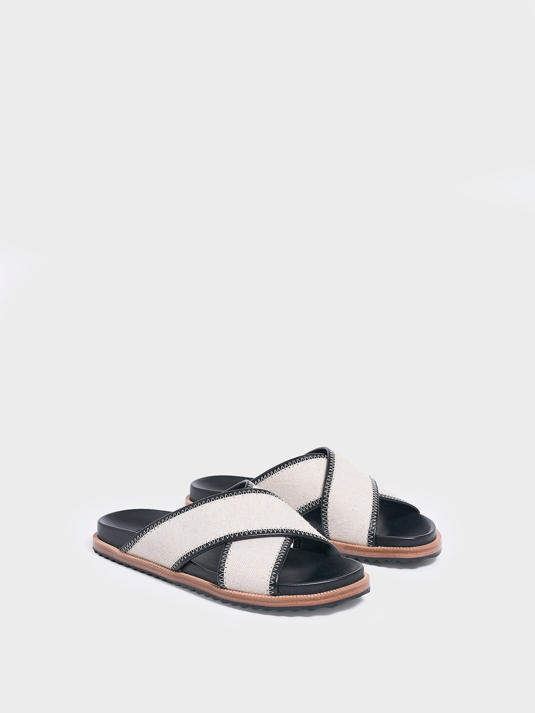 Angle view of a pair of salt and pepper linen molded footbed slide sandals.