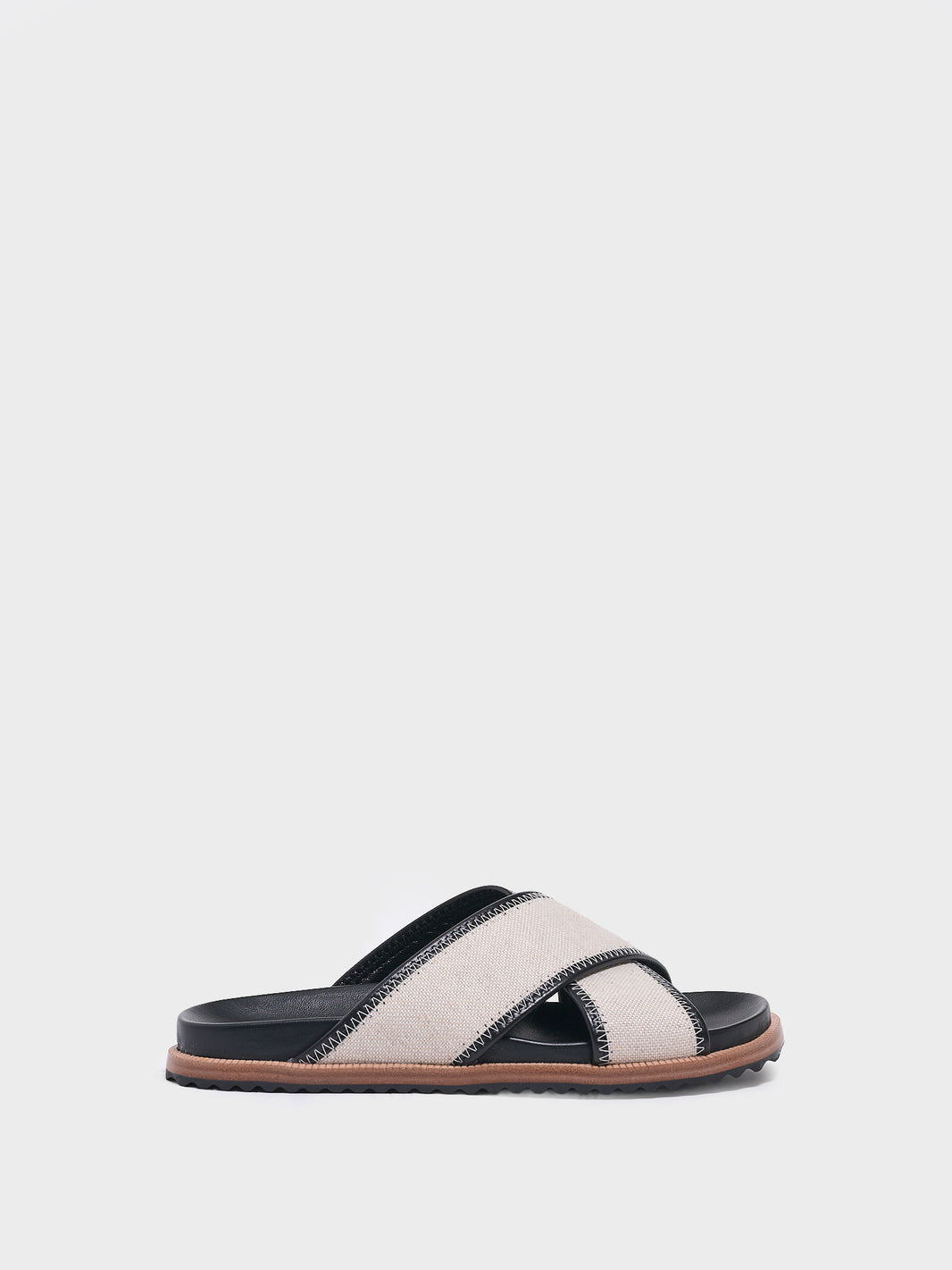 Profile view of a salt and pepper linen molded footbed slide sandal.