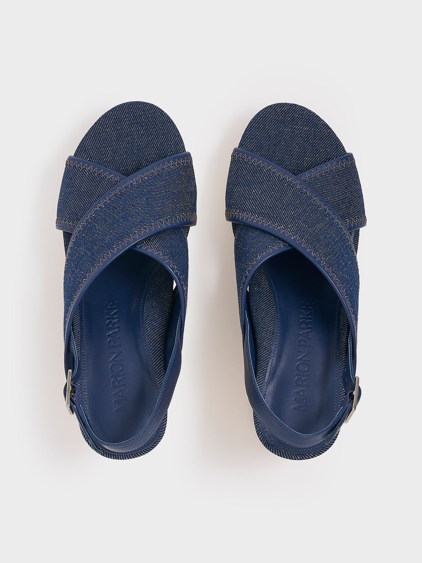 Top view of a pair of navy denim platform sandals with an adjustable back strap.