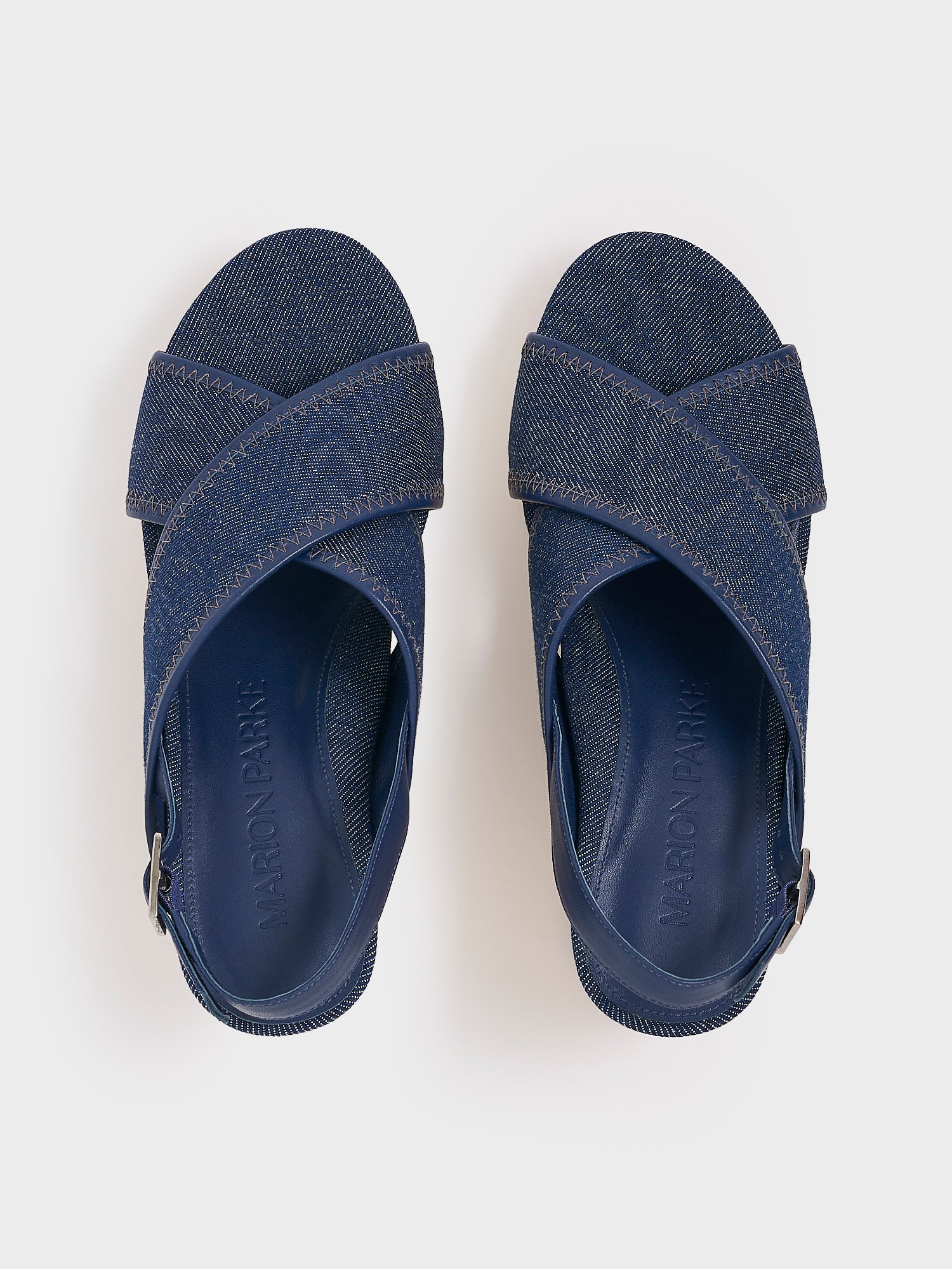 Top view of a pair of navy denim platform sandals with an adjustable back strap.
