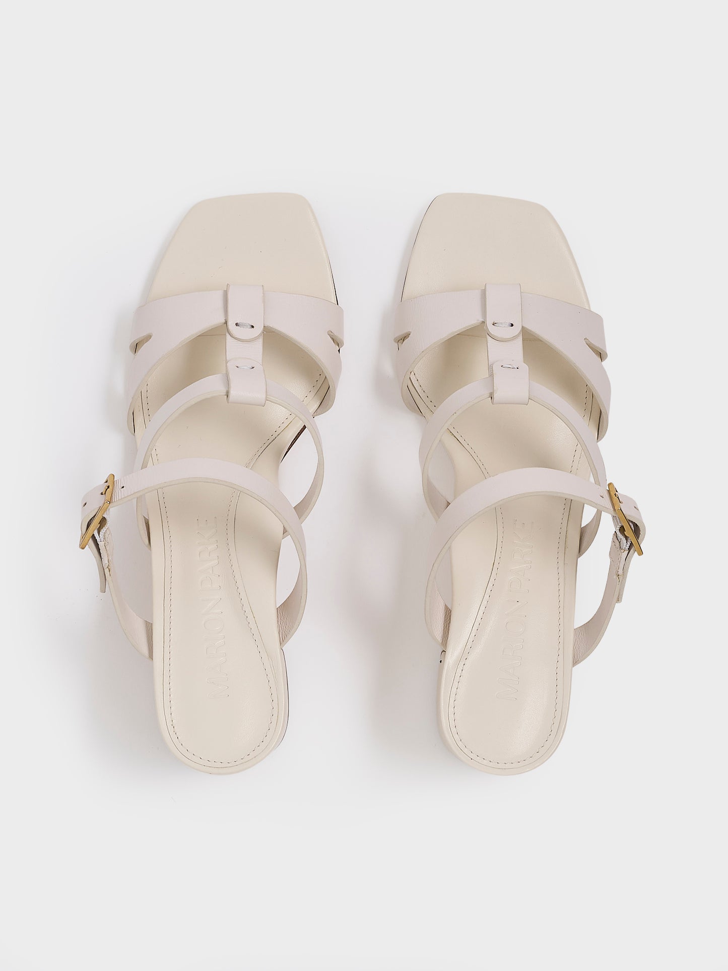 Top view of a pair of ivory leather gladiator block heel sandals.
