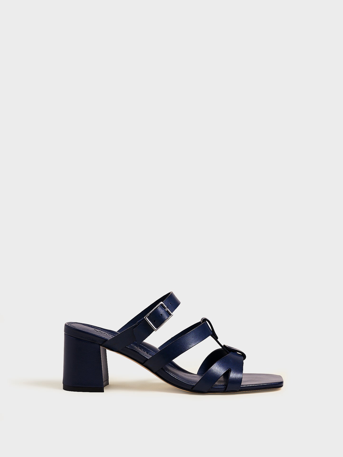 Profile view of an navy nappa leather gladiator block heel sandal.