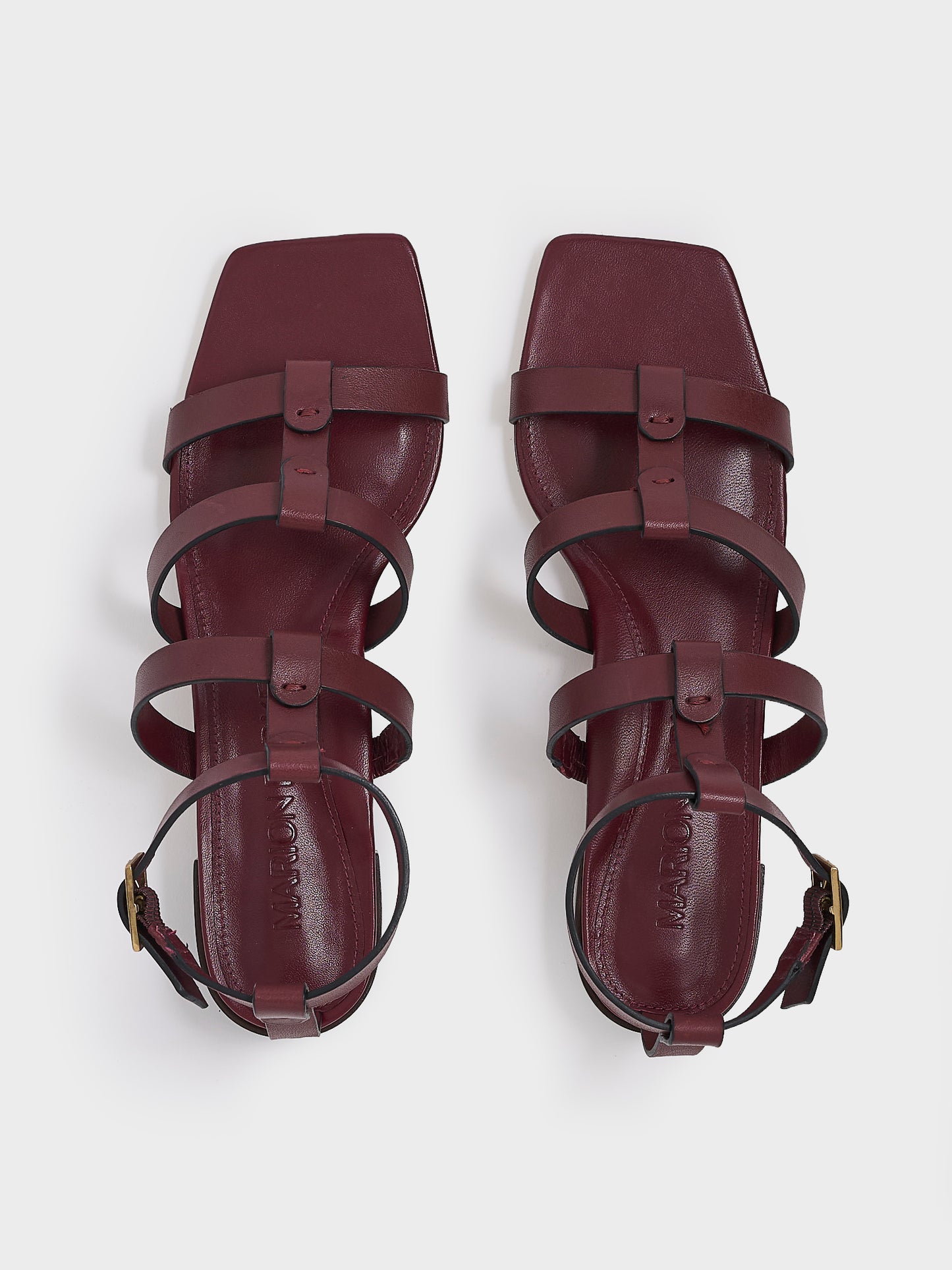 Top view of a pair of burgundy leather gladiator sandals with an adjustable ankle strap.