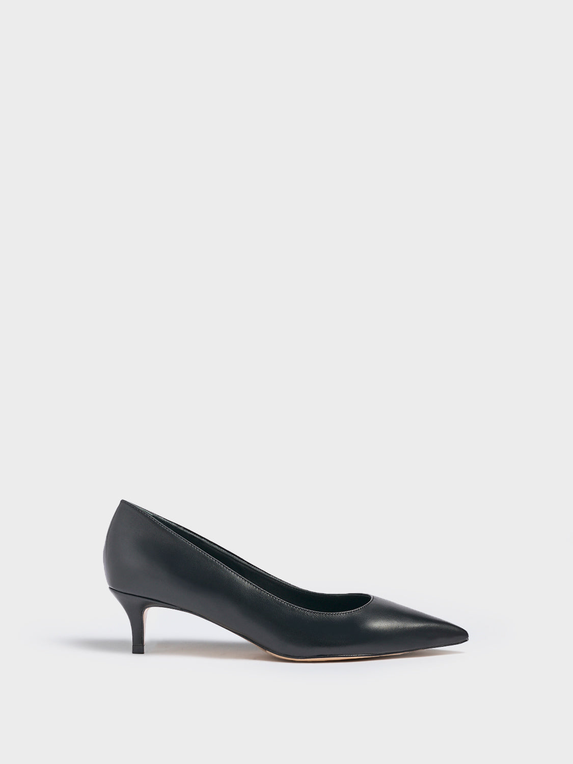 Profile view of a black leather kitten heel pump with a pointed toe.