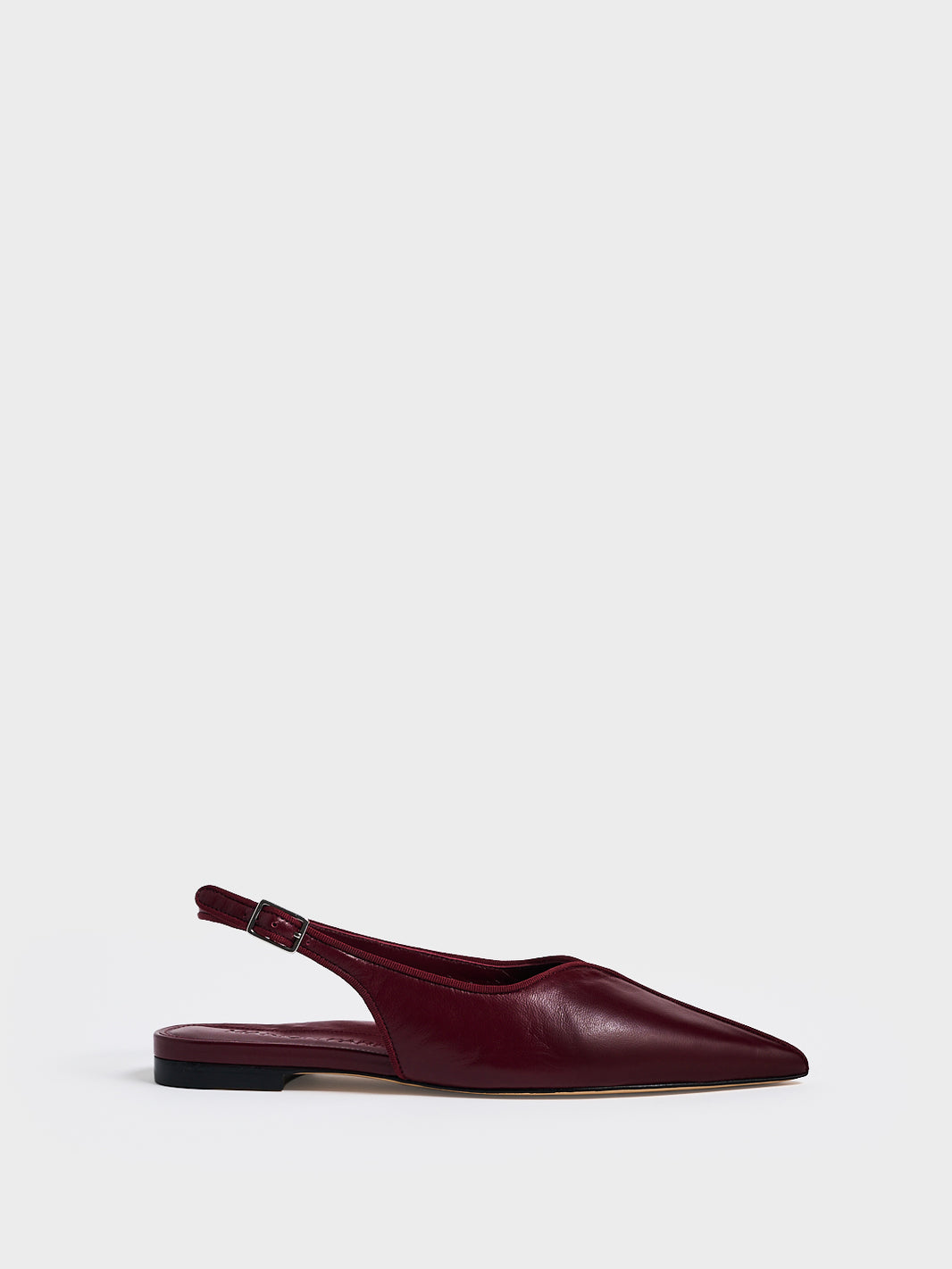 Profile view of a burgundy leather slingback flat with a grosgrain trim detail.