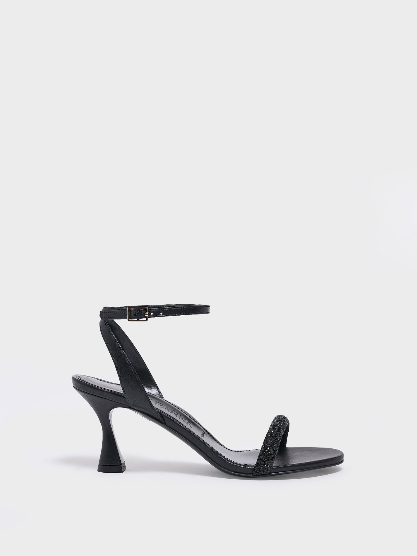 Profile view of an black leather high heel sandal with a crystal embellished toe strap and adjustable ankle strap.