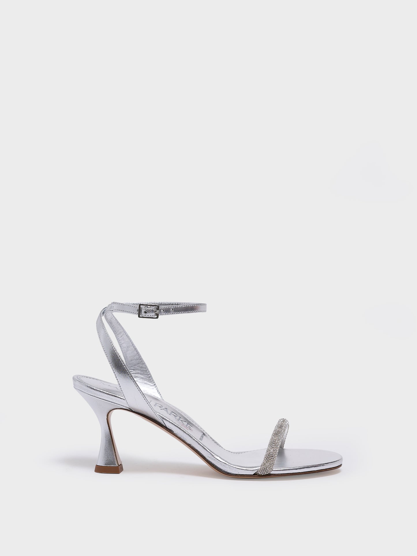 Profile view of an silver metallic leather high heel sandal with a crystal embellished toe strap and adjustable ankle strap.