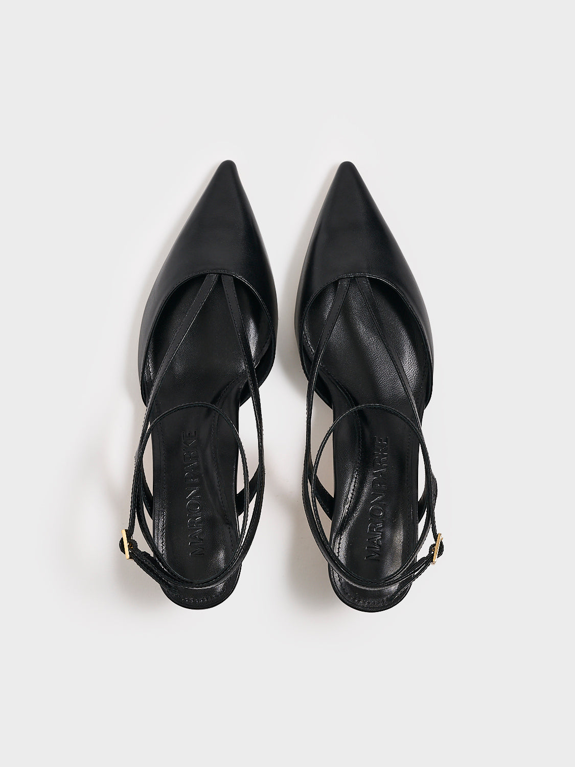 Top view of a pair of black leather kitten heels with sculpted strap design and an adjustable ankle strap.